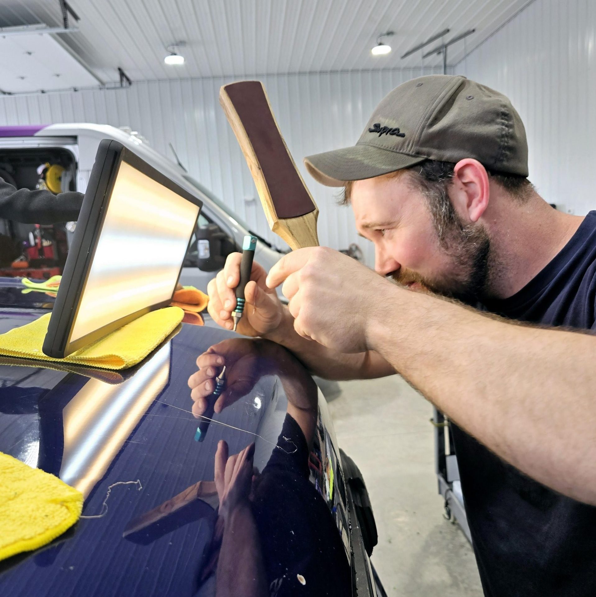 men doing paintless dent repair marking